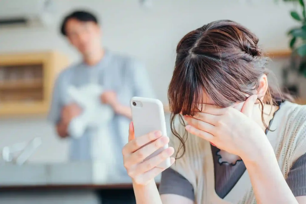 夫のスマホのLINEを見てショックを受ける女性