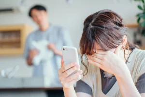 夫のスマホのLINEを見てショックを受ける女性